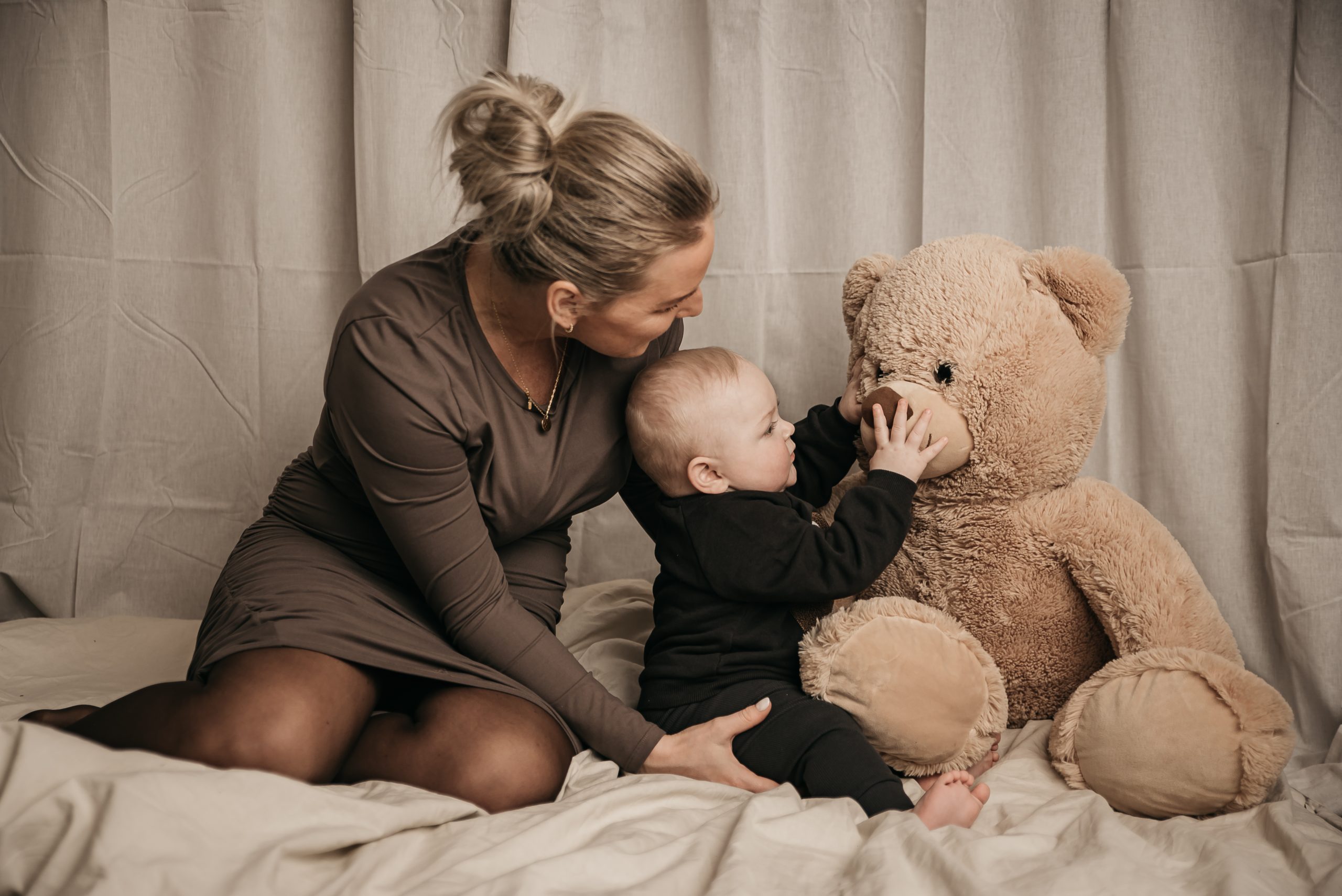 Mor og søn i fotostudie med kæmpe bamse
