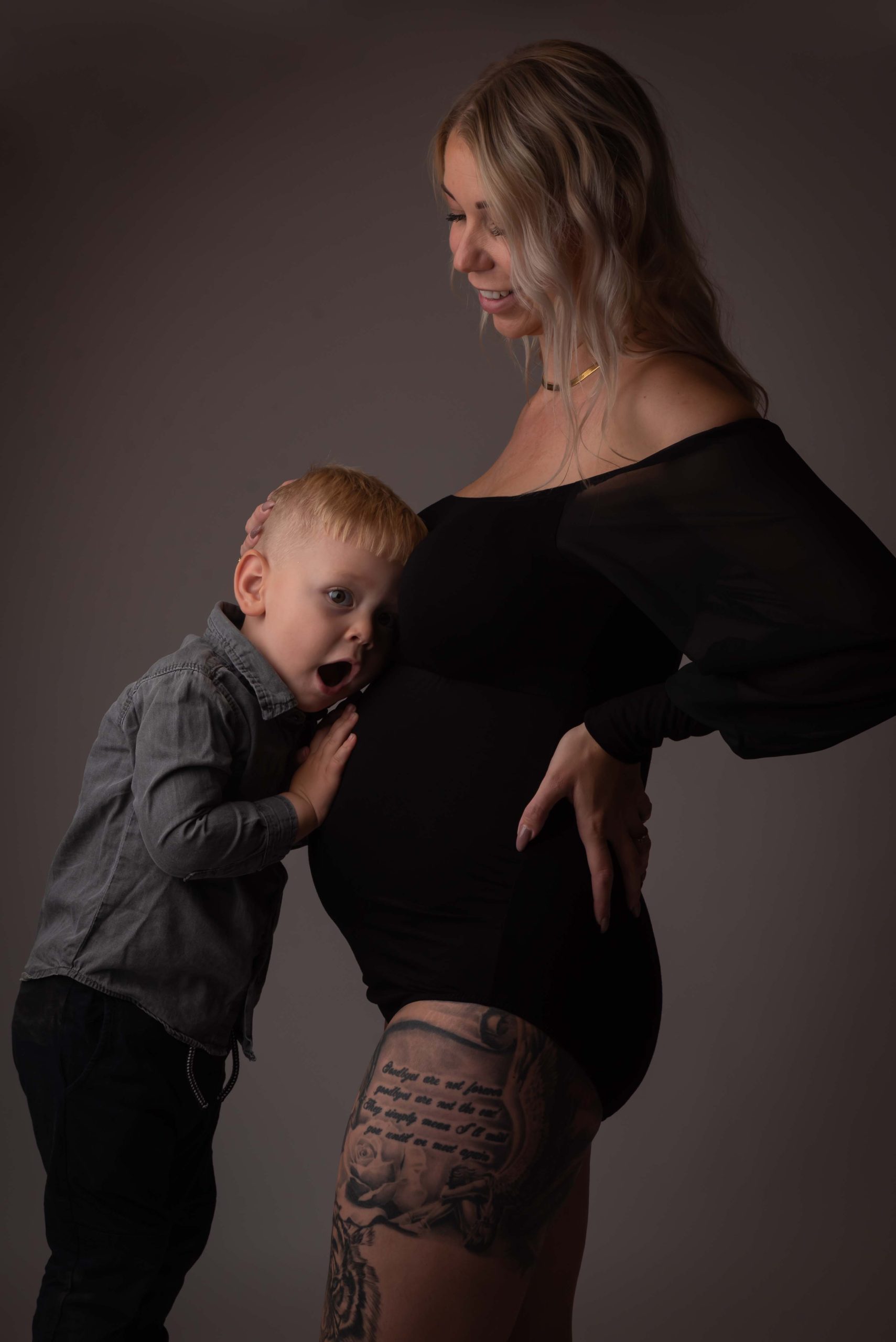 Dreng lytter til sin mors gravide mave