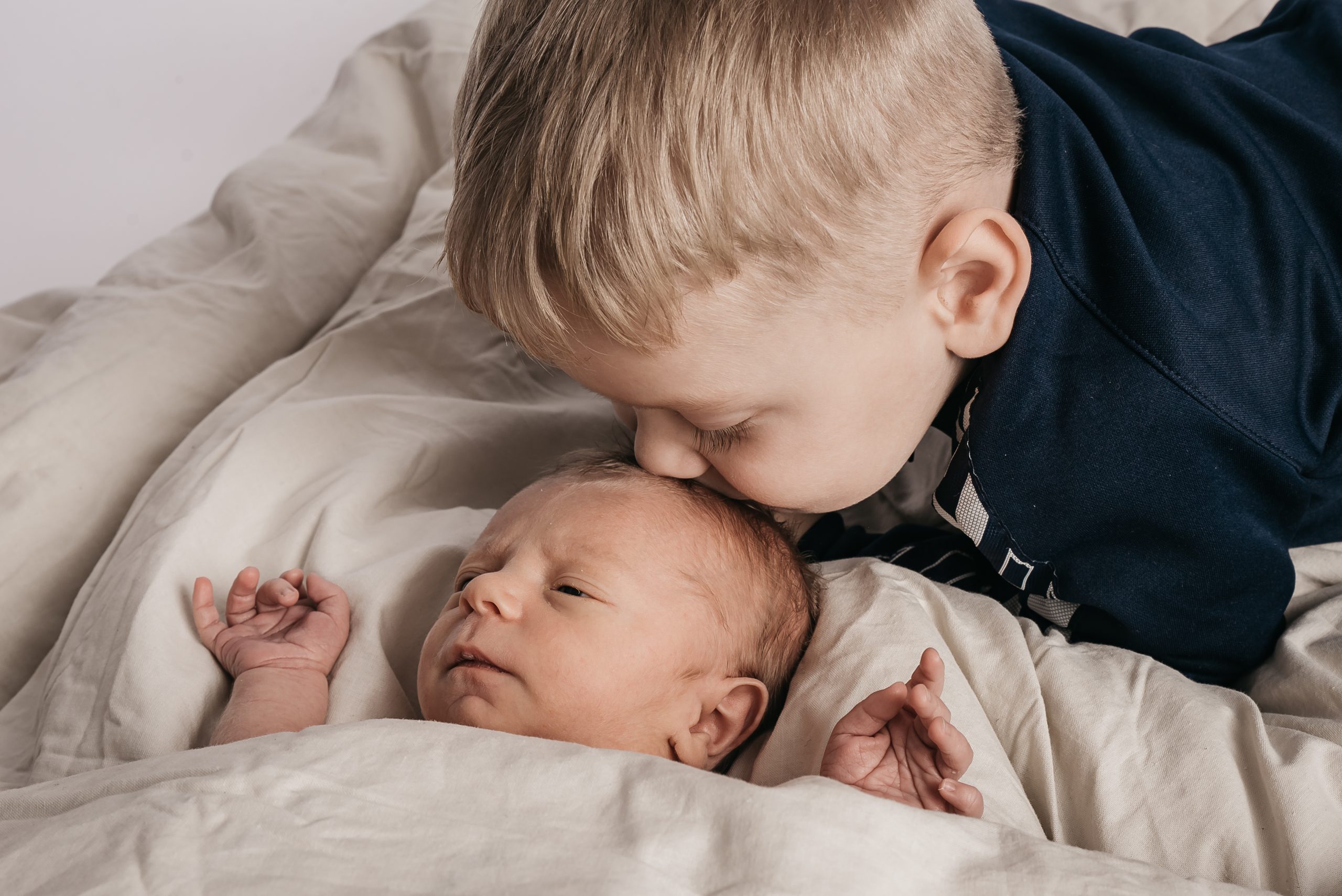 storebror kysser nyfødt lillebros
