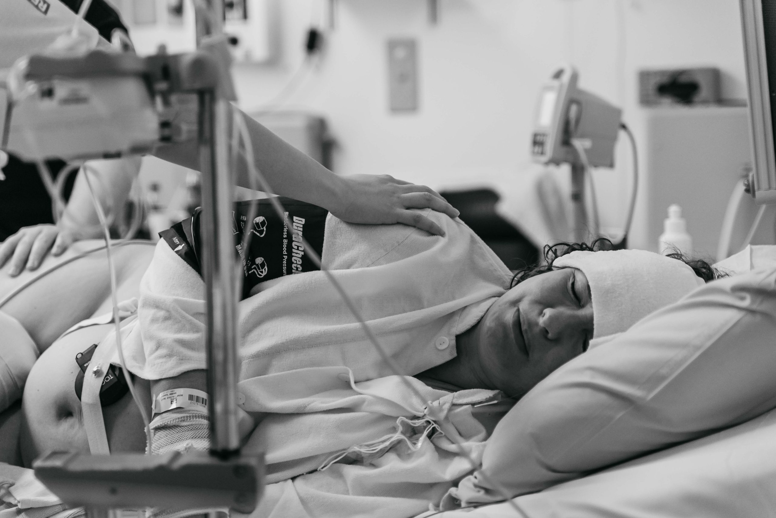 fødende kvinde ligger i hospitalsseng og får vedrop