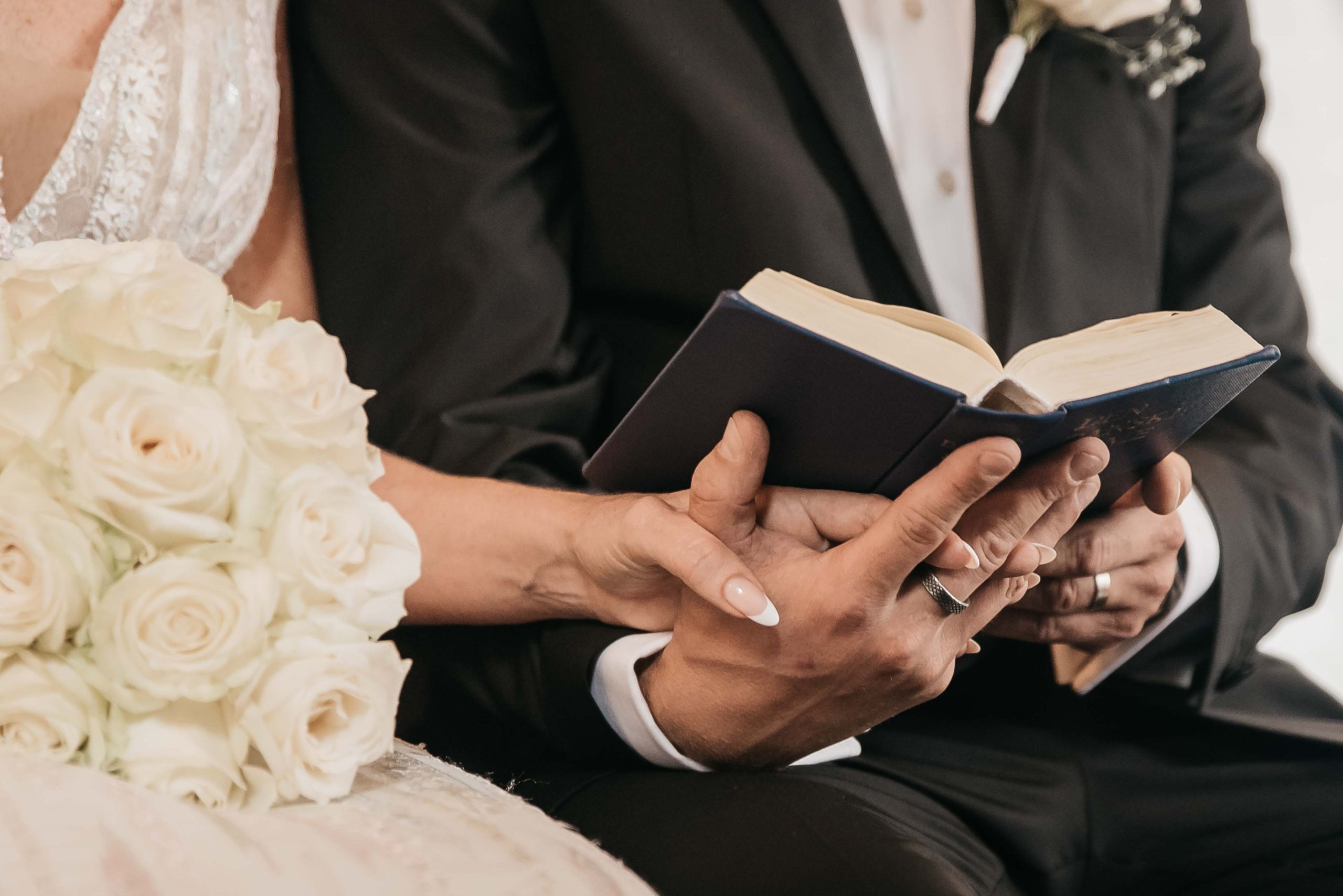 nygift brudepar holder i hånden i kirken